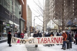 Photo of a trans rights protest. A banner saying 